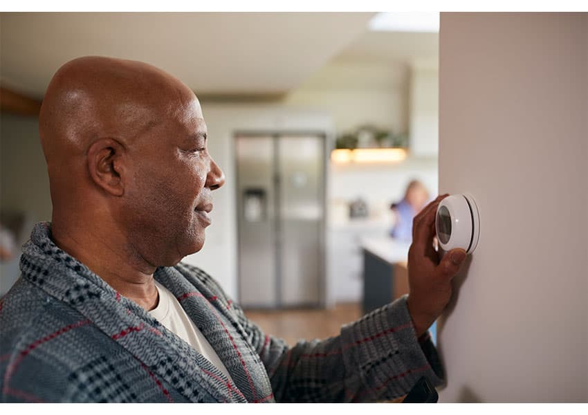 man adjusting thermostat